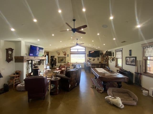 Spacious living room with rustic decor, high ceiling, and wooden furnishings.