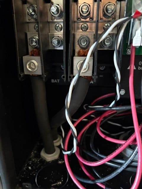 Close-up of electrical connections and wiring in a battery compartment of a power device.
