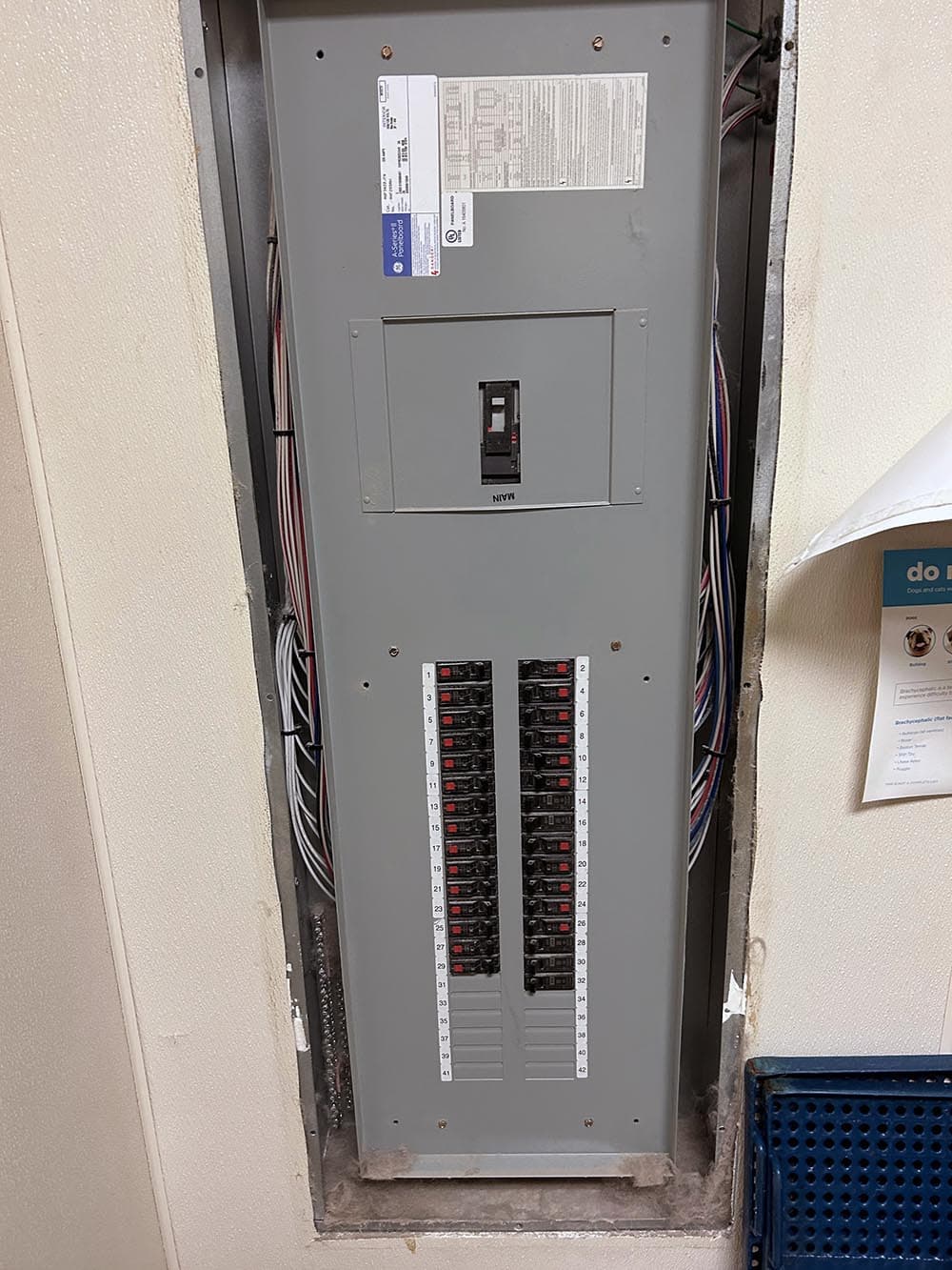 Electrical panel with multiple circuit breakers and labeled switches in a residential setting.